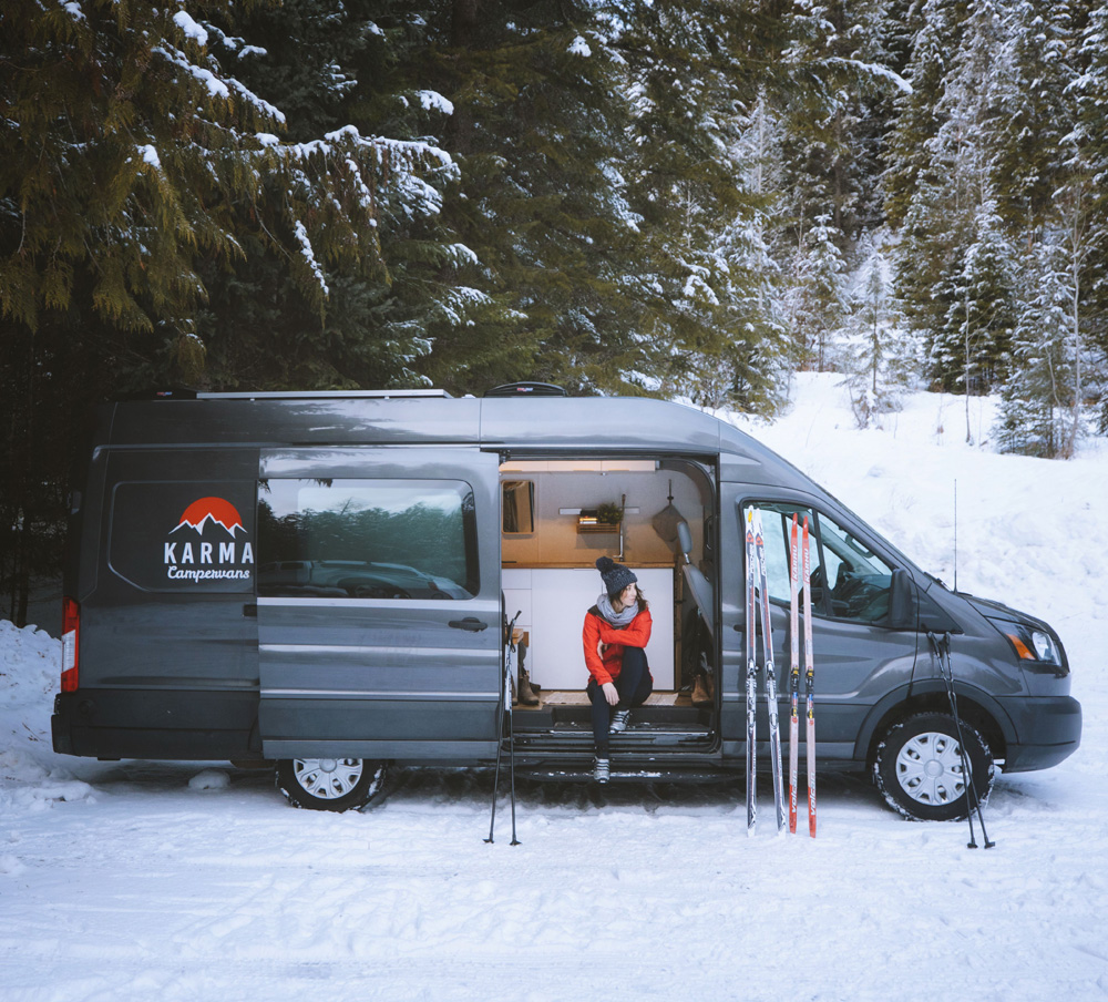 Karma Campervan parked in the snow with cross-country skis leaning against it